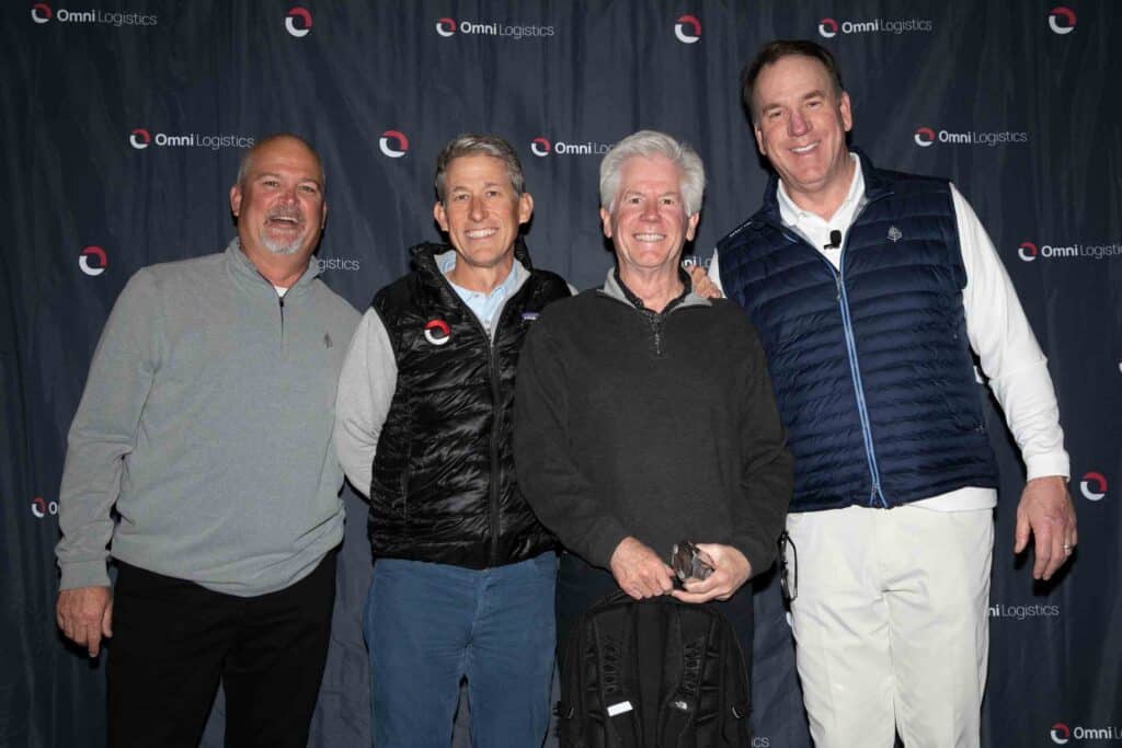 award winner standing with executives